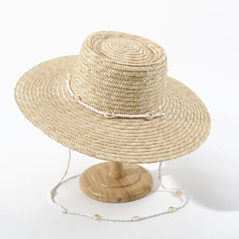 A Large Eaves Straw Hat with a Concave Top for Summer, Featuring a Streamer, Designed for Sun Protection at European And American Beaches, Also Known As a Russian Straw Hat