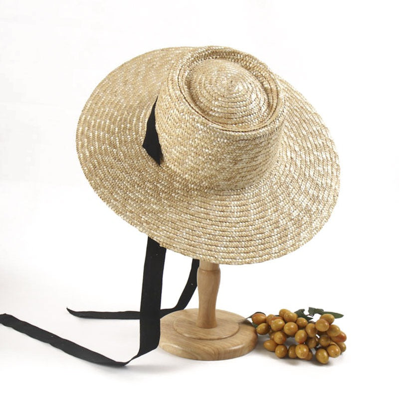 A Large Eaves Straw Hat with a Concave Top for Summer, Featuring a Streamer, Designed for Sun Protection at European And American Beaches, Also Known As a Russian Straw Hat